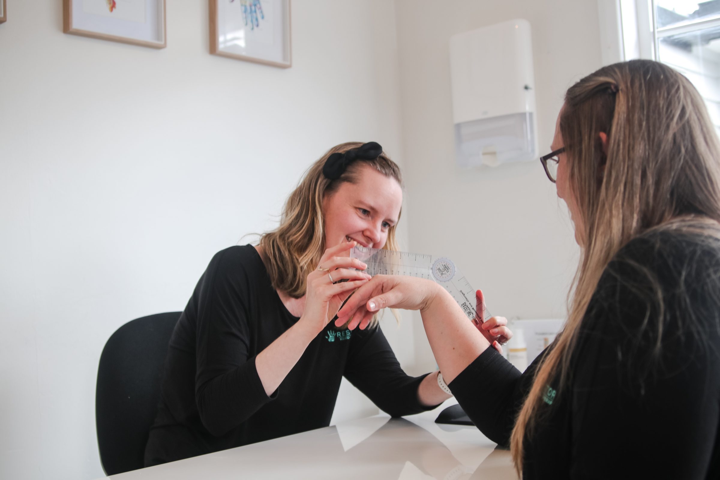 A patient and therapist sharing a light moment during a hand exercise