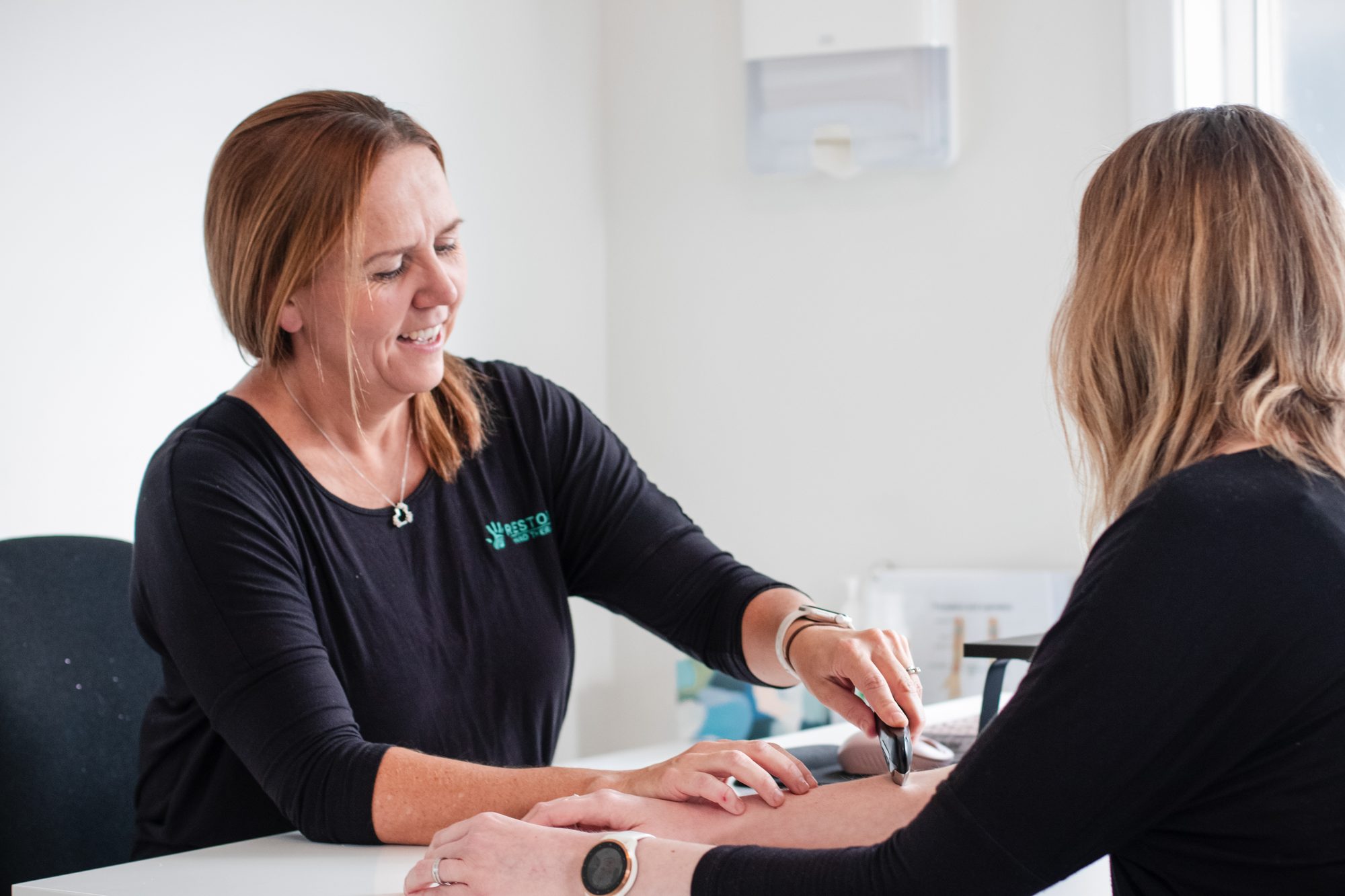 A Restore therapist listening to a patient during a hand assessment