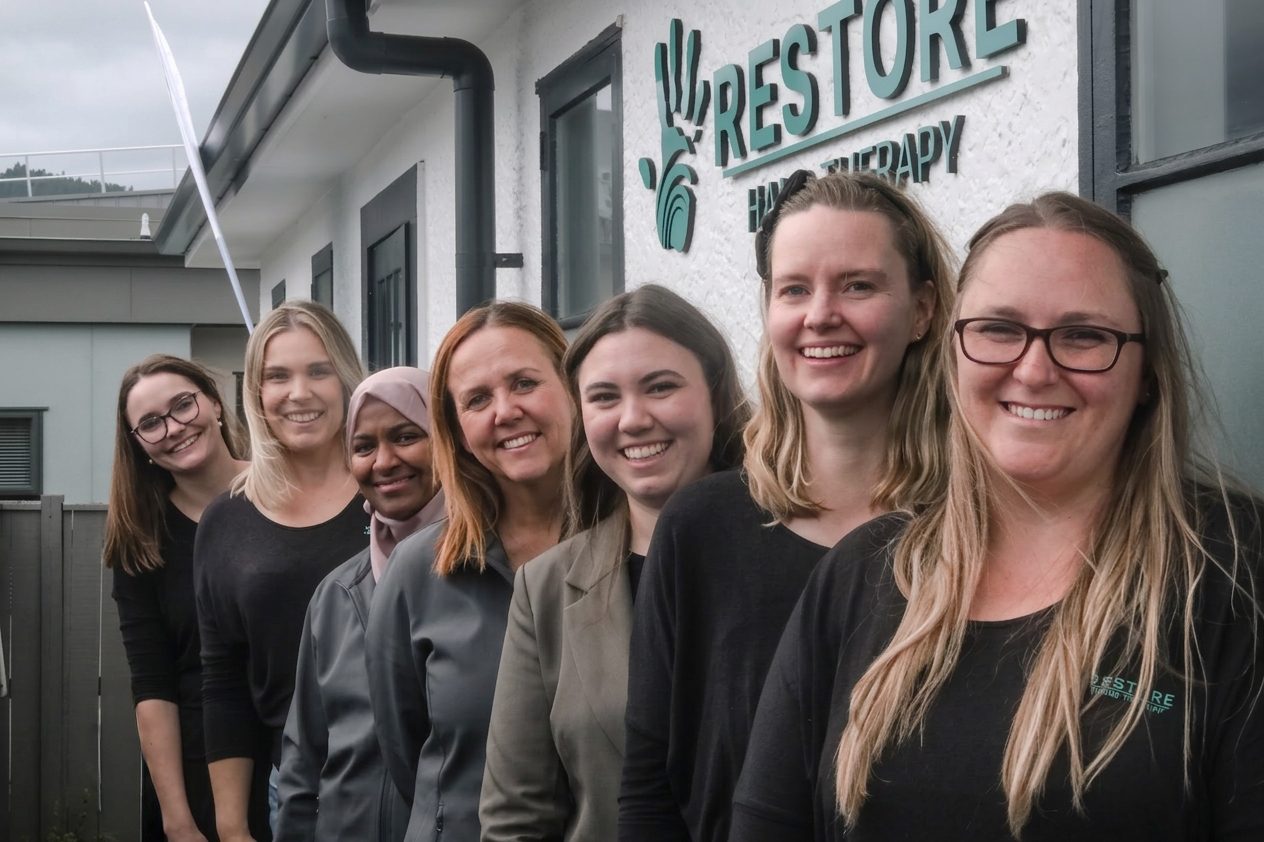 The Restore Hand Therapy team smiling together outside their Upper Hutt clinic